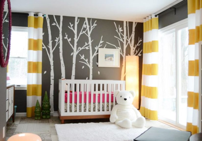 A Dark Gray Nursery With A Tree Mural & Striped Curtains